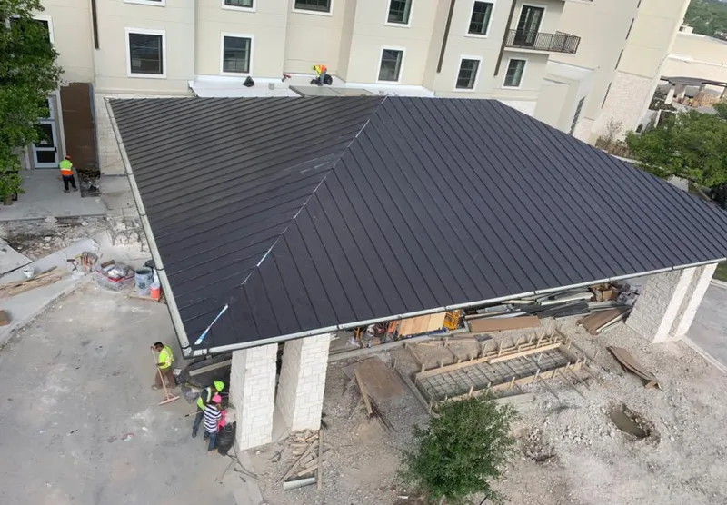Metal roofing installation team working on a commercial building in Orchard Mesa